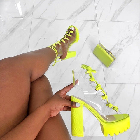 Stylish women's high heel sandals in vibrant yellow with clear straps, perfect for summer outfits or special occasions.